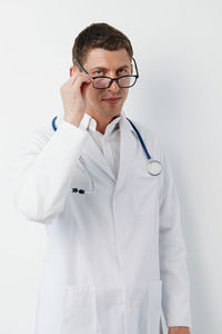 Portrait of doctor standing against white background