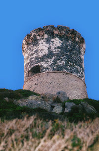 Low angle view of fort against clear blue sky