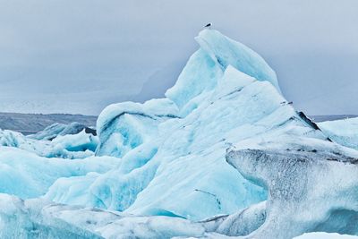 Glacier in sea against sky