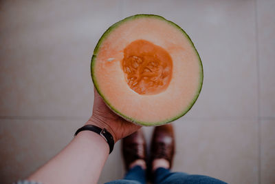 Midsection of person holding melon 