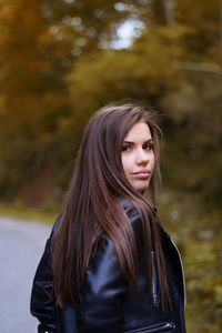 Portrait of beautiful young woman standing on footpath 