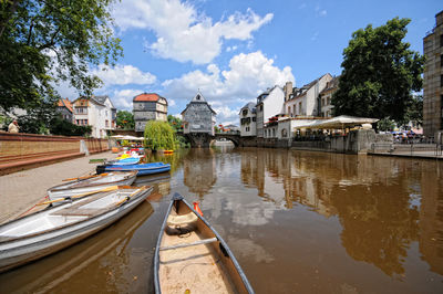 Boats moored on lake against sky