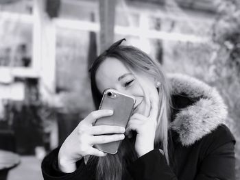 Smiling woman taking selfie through mobile phone