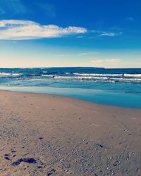 Scenic view of beach against blue sky