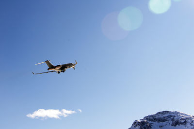 A private jet flying up in the blue sky in engadine st moritz