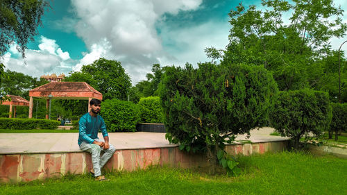 Rear view of man sitting against trees