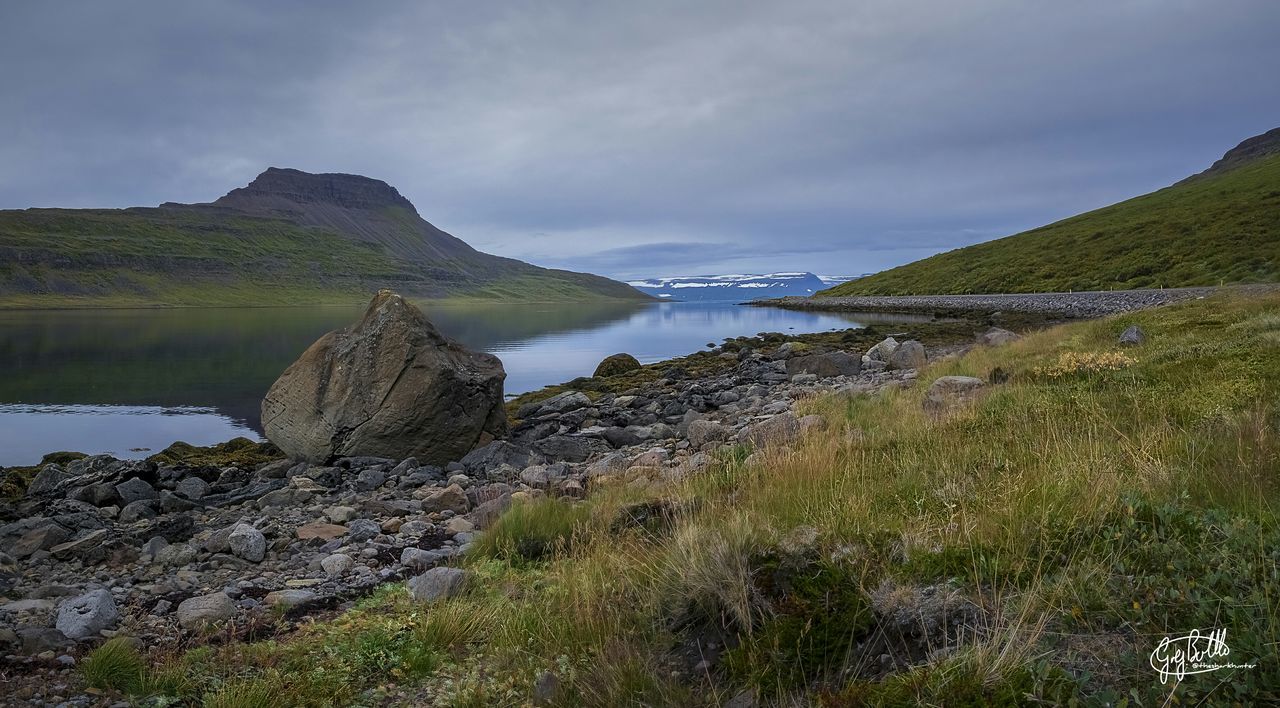 sky, tranquil scene, water, tranquility, scenics, beauty in nature, nature, cloud - sky, grass, landscape, plant, mountain, cloud, sea, cloudy, lake, idyllic, non-urban scene, remote, day