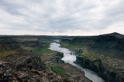 Scenic view of waterfall against sky