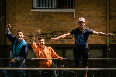 Happy friends standing against the wall