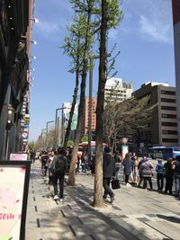 People on street in city against sky
