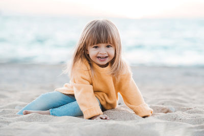 Portrait of young woman sitting at beach