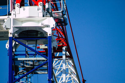 Low angle view of ferris wheel against clear blue sky