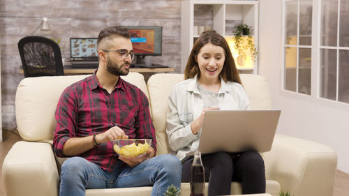Man and woman watching laptop at home