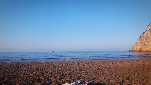 Scenic view of beach against clear blue sky
