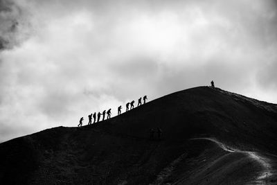 People on mountain against sky