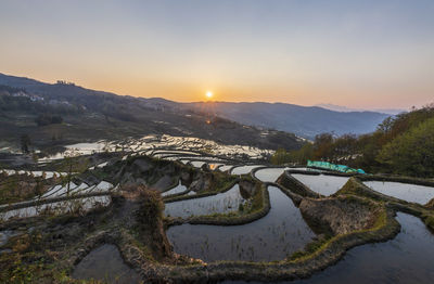 Scenic view of river against sky during sunset