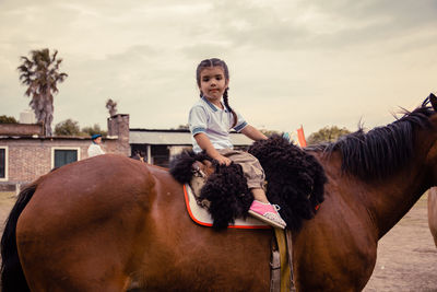 Portrait of little girl riding horse