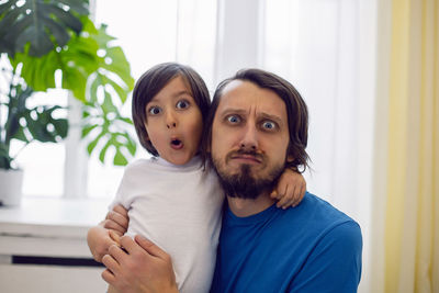 Father and son having fun sitting by the window