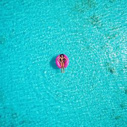 Woman relaxing in inflatable ring on swimming pool