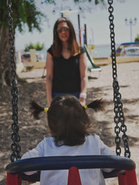 Rear view of girl sitting on swing at playground