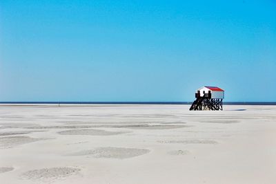 Man on beach against clear blue sky