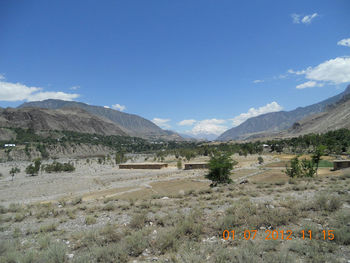 Scenic view of landscape and mountains against blue sky