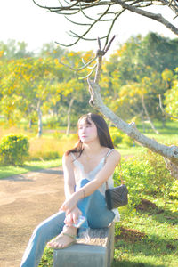 Portrait of smiling young woman sitting on field