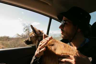 Young woman with horse in car