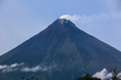 Low angle view of volcanic mountain against sky