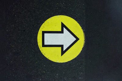 Close-up of arrow sign on road
