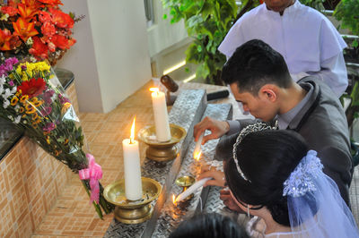 High angle view of couple igniting candle during wedding