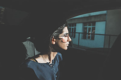 Young woman wearing sunglasses while sitting in car