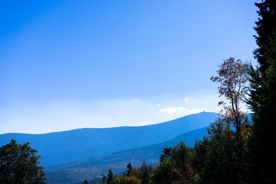 Scenic view of mountains against blue sky