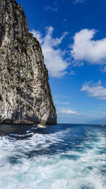 Rock formation in sea against sky