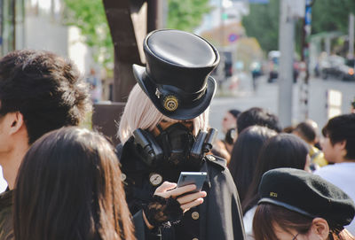 Person in costume using mobile phone in city