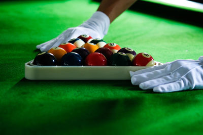 Cropped hand of man playing pool ball