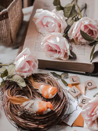Beautiful pink rose on opened pages book with aritificial bird with nest
