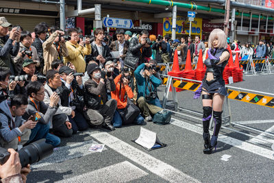 Group of people standing on road in city