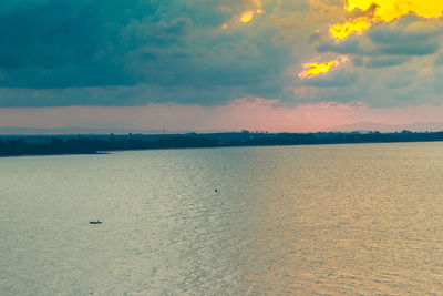 Scenic view of beach against sky at sunset