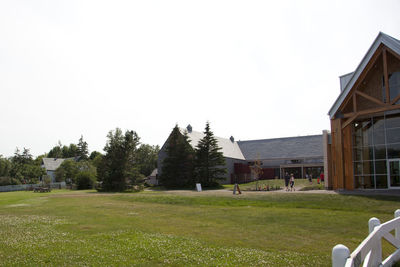 Houses on field against clear sky