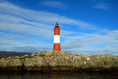 Lighthouse by sea against sky