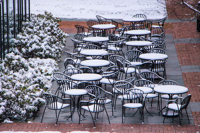 Empty chairs and tables in snow