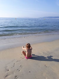 Full length of boy on beach against sky