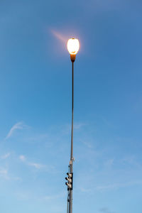 Low angle view of illuminated street light against sky