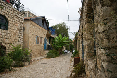 Footpath amidst buildings against sky