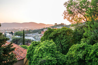 High angle view of townscape by sea against sky during sunset