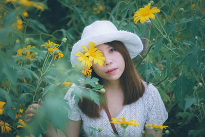 Portrait of woman with yellow flower