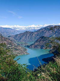 High angle view of lake and mountains against blue sky