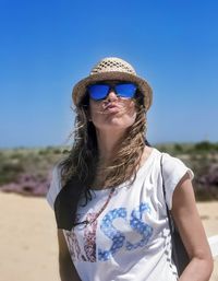 Portrait of young woman standing at beach