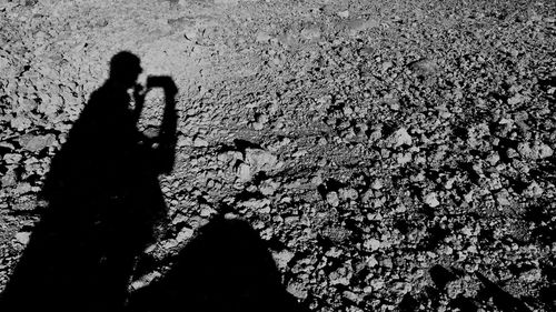 Silhouette woman standing by shadow on ground